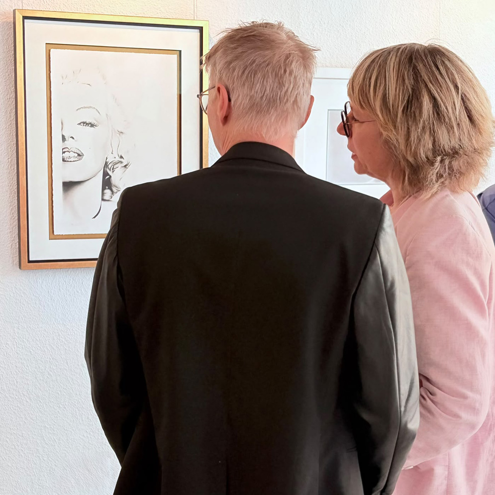 Besucher betrachten Portraitzeichnungen von Dirk Richter