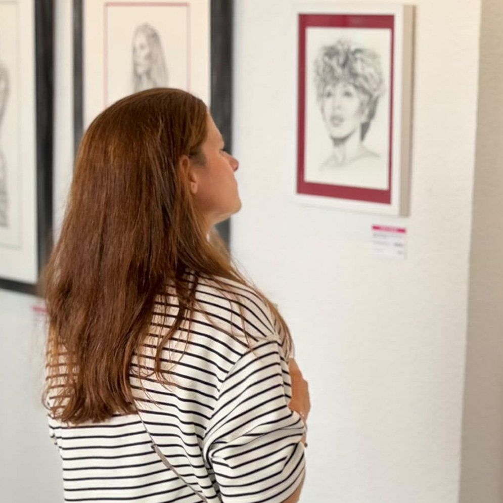 Besucher betrachten eine Bleistiftzeichnung bei Dirk Richters Einzelausstellung